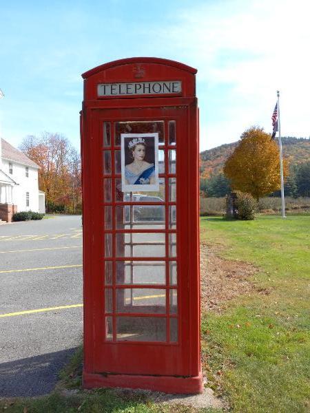 red tardis phone booth with photo of queen taped to it